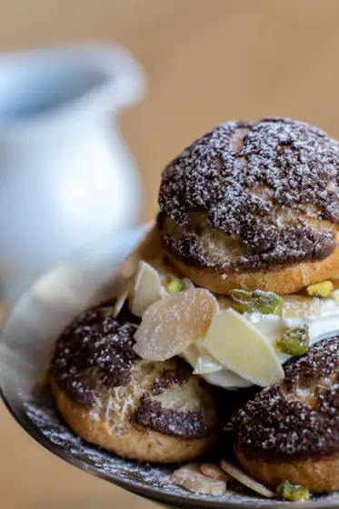 Choux craquelin au cacao garnis de chantilly, amandes effilées et pistaches