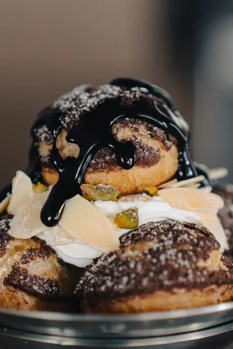 Gros plan sur des choux nappés de chocolat brillant et garnis de chantilly