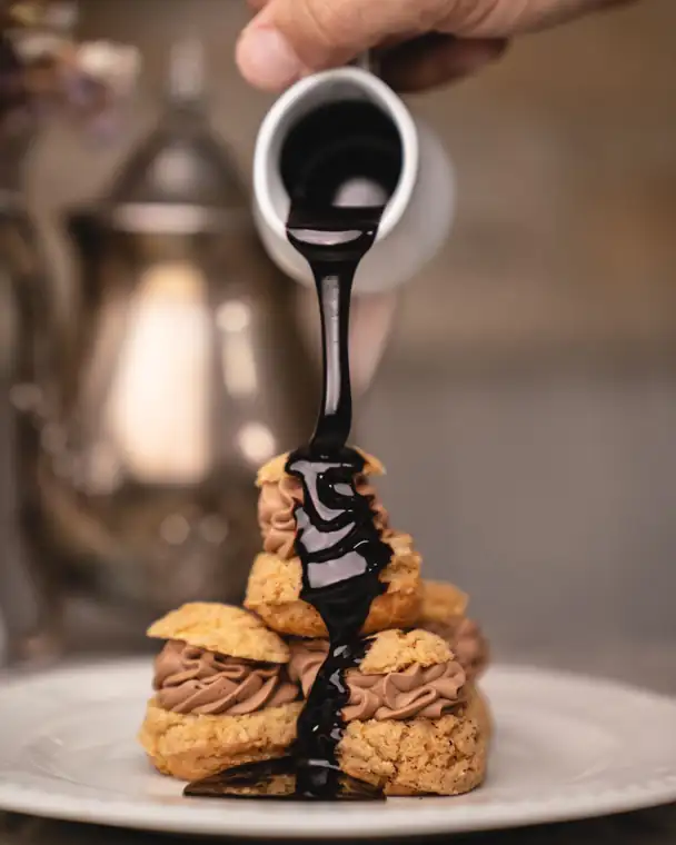 Nappage de chocolat versé sur une pyramide de choux garnis de crème au chocolat